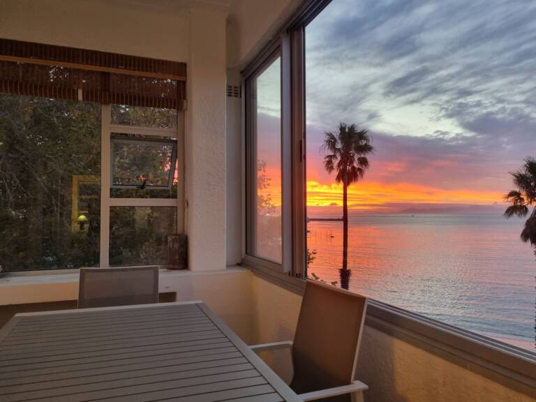 top flat gordons bay 29 enclosed veranda with sunset on beach 768x576